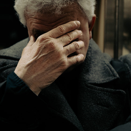 Man covering his face with hand. The weight we carry often shows in the ways we try to hide it. In a single gesture, silence speaks louder than words.