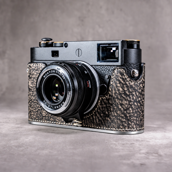 A Leica M11 in the Buffalo SlimCase with a silver lens fitted, three quarter view