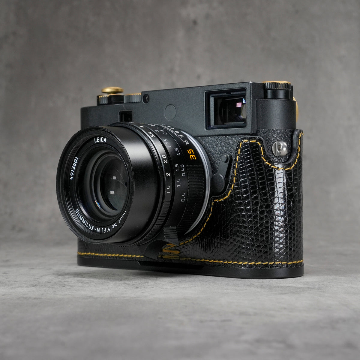 Leica M11 in a black gloss lizard FlexCase, front three-quarter view from the left