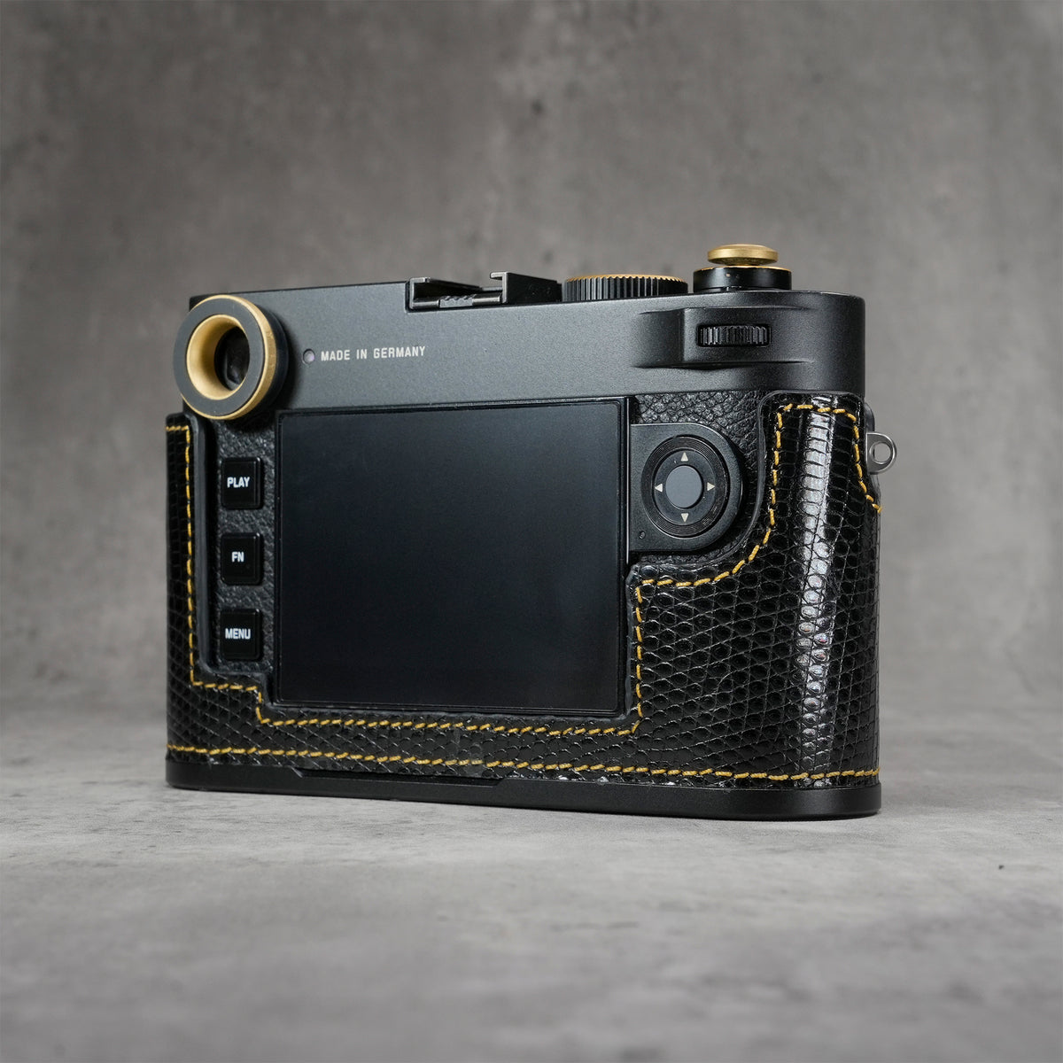 Camera in a black gloss lizard FlexCase seen from the back, screen and controls clear of the leather