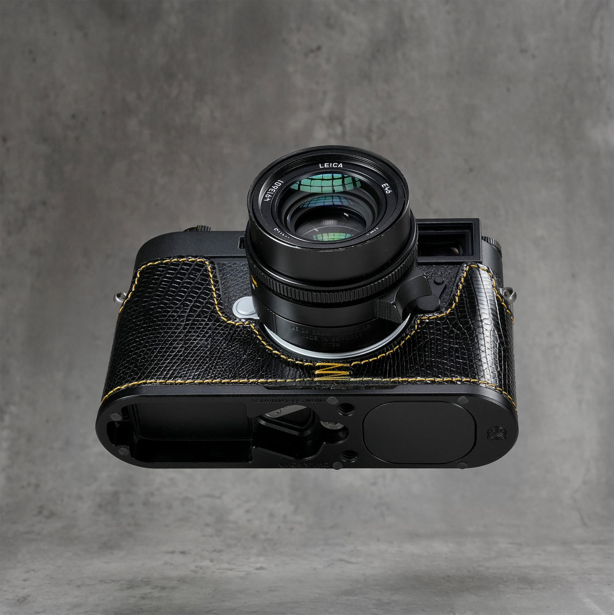 Leica M11 in a black gloss lizard FlexCase seen from below, Black Chrome base plate showing