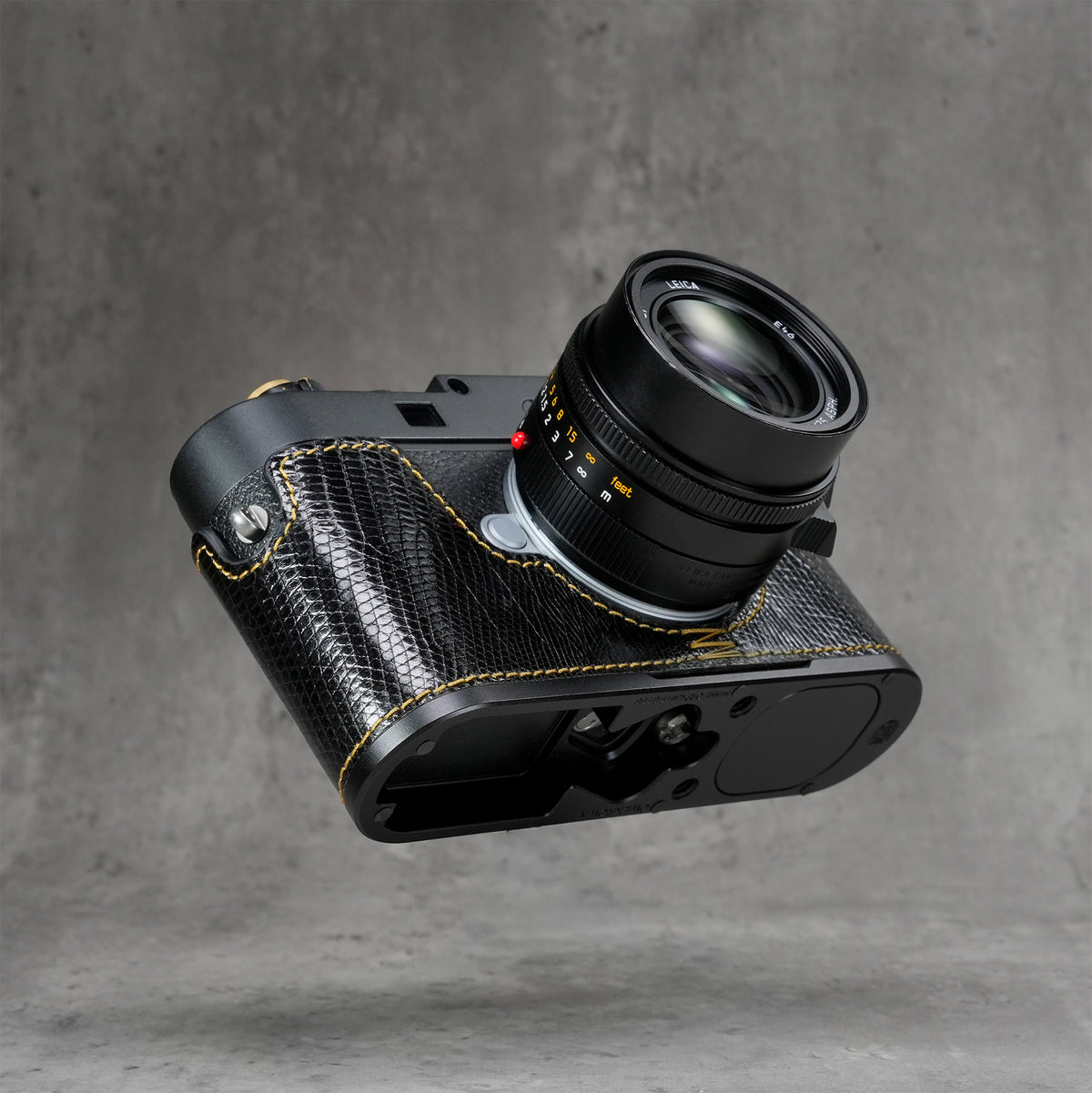 Black gloss lizard FlexCase on a Leica M11, three-quarter view from below of the Black Chrome base plate