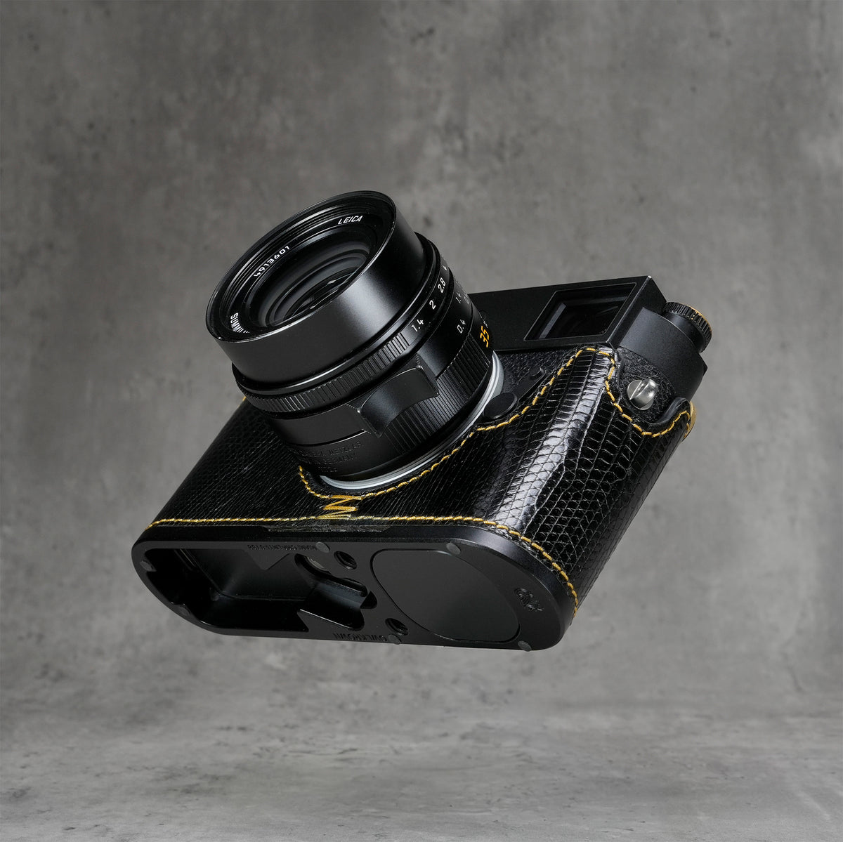 Underside of the black gloss lizard FlexCase on a Leica M11, base plate cutouts showing