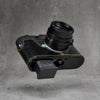 Battery released from a Leica M11 with the black gloss lizard FlexCase still fitted