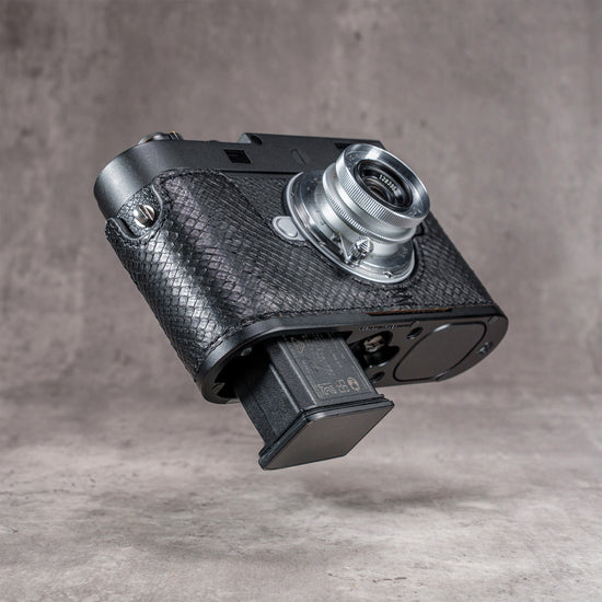 Battery dropping clear of the base plate with the black python FlexCase still on the camera