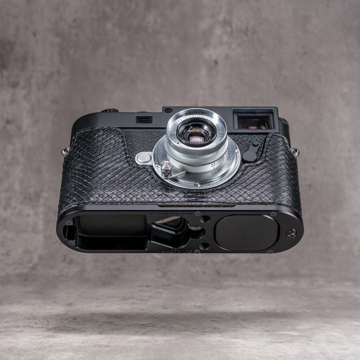 Leica M11 in a black python FlexCase seen from below, base plate cutouts showing