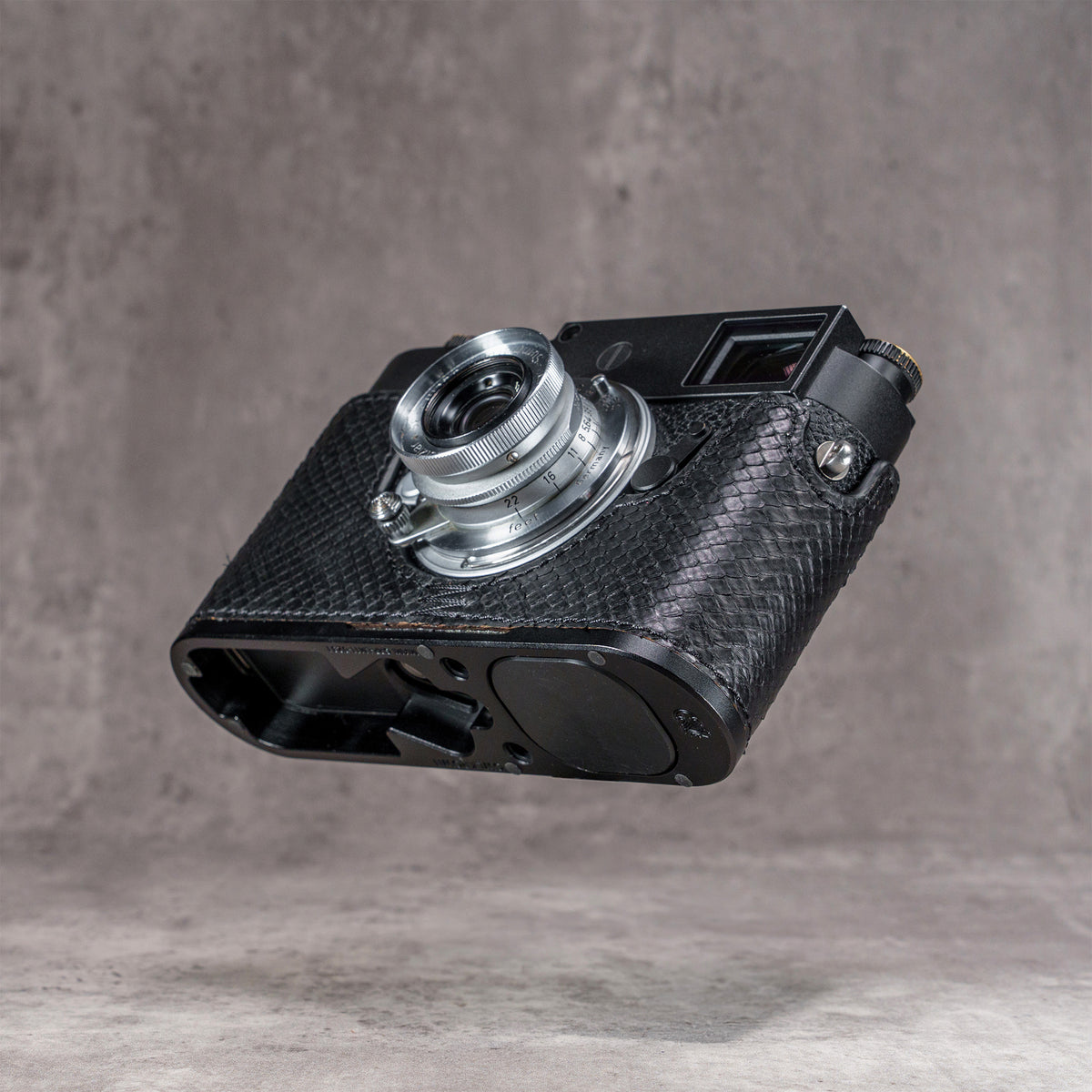 Black python FlexCase on a Leica M11, low three-quarter view of the base plate