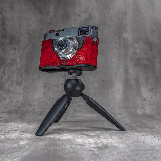 Leica M11 in a red python FlexCase mounted on a tabletop tripod