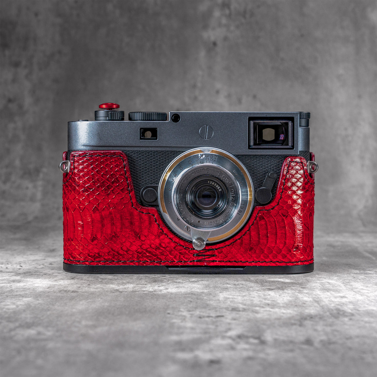 Leica M11 in a red python FlexCase, front view on a grey studio backdrop