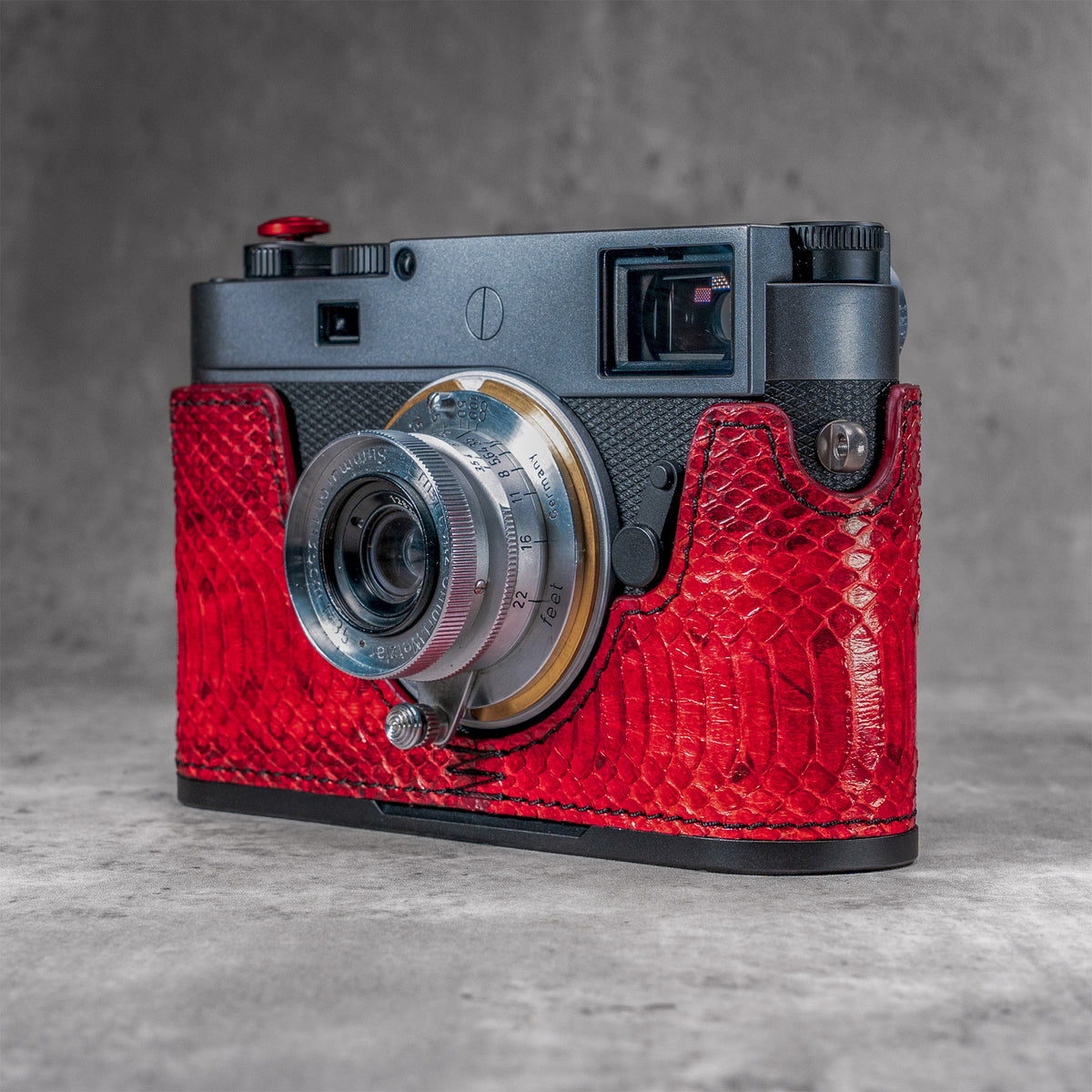 Red python FlexCase on a Leica M11, front three-quarter view from the left