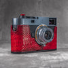 Leica M11 in a red python FlexCase, front three-quarter view with the lens forward