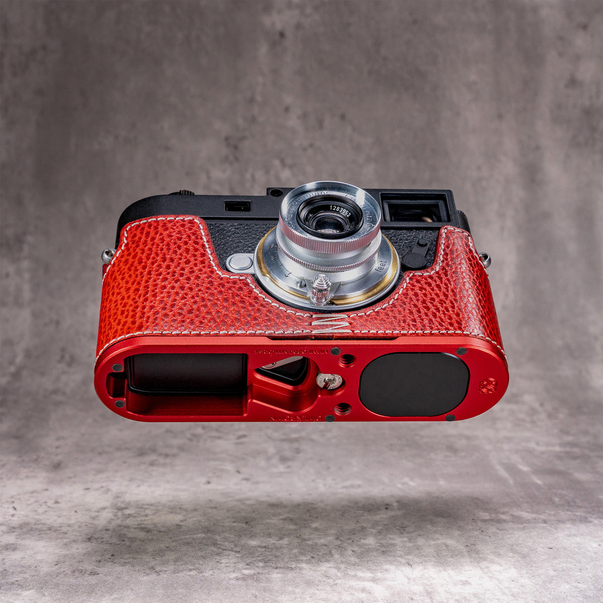 Base of the Ruby Gloss FlexCase, OxBlood anodized plate with the AirTag bay and the anti skid pad