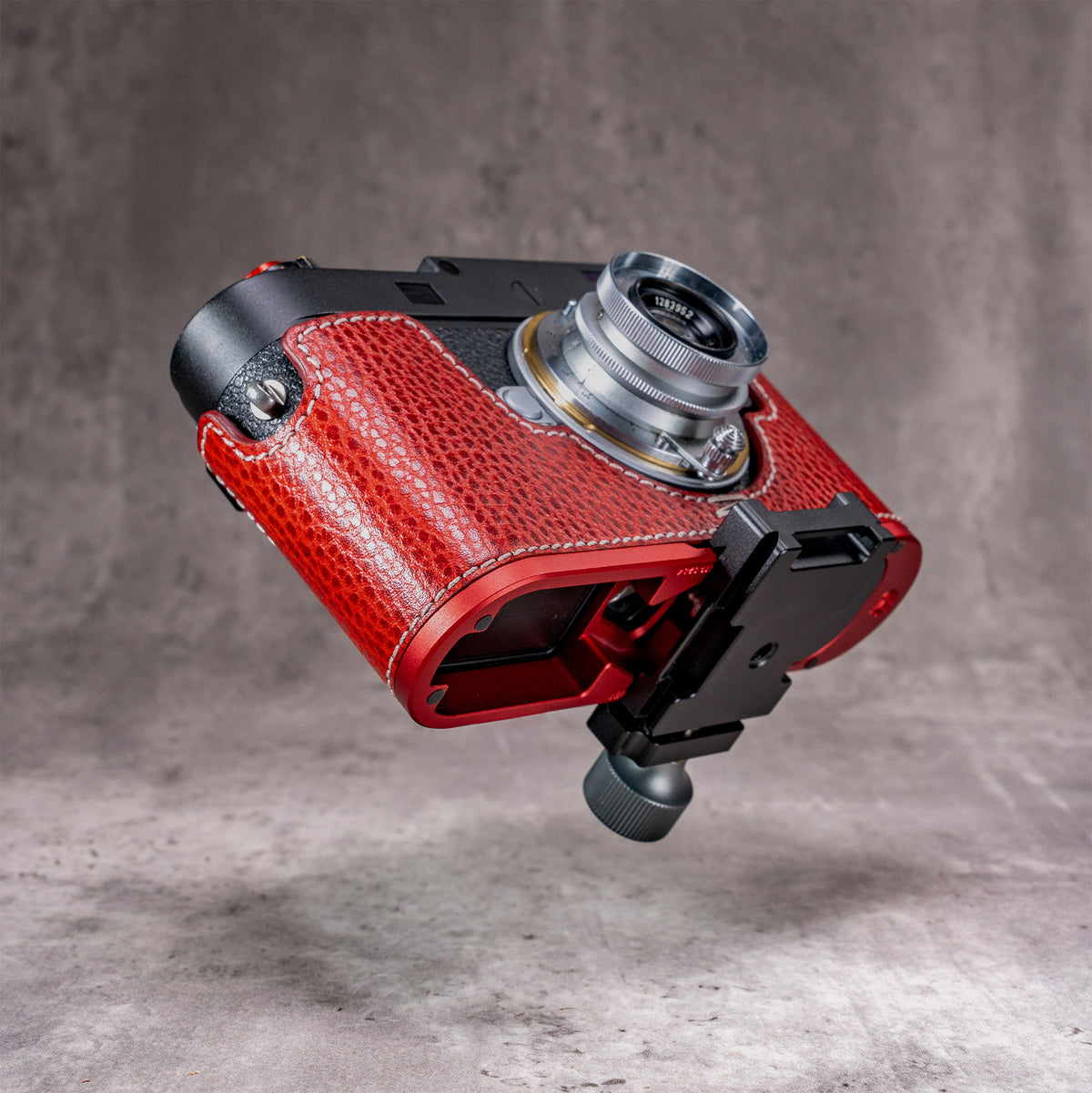 Leica M11 in the Ruby Gloss FlexCase dropped onto an Arca clamp, using the profile machined into the OxBlood plate