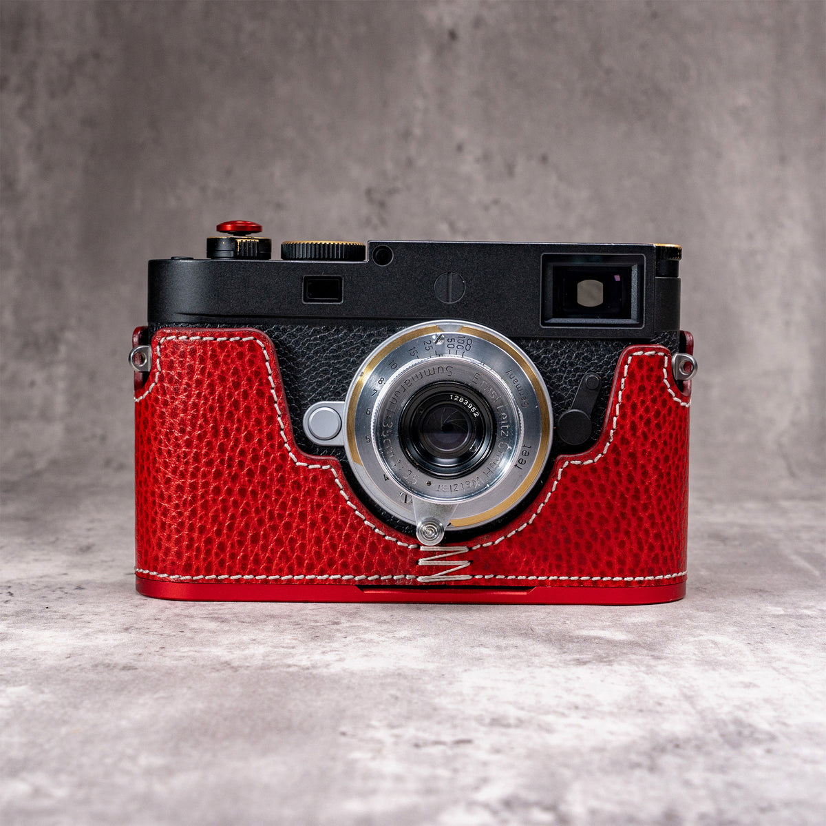 Ruby Gloss FlexCase on a Leica M11, front view showing the red pebbled leather and cream stitching