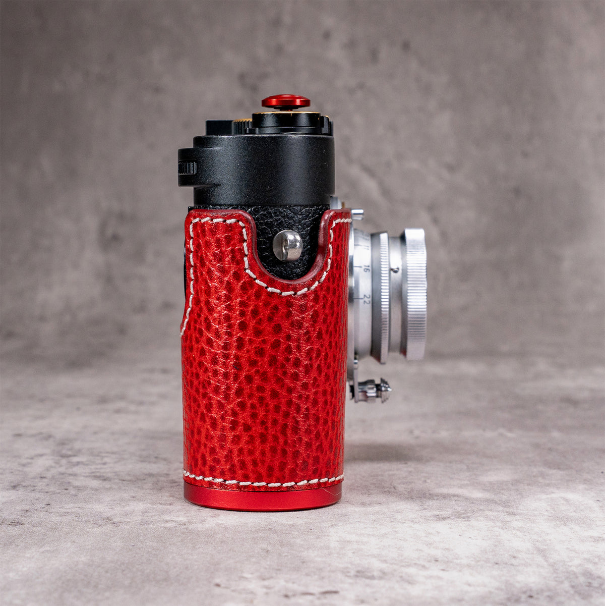 Side profile of the Ruby Gloss FlexCase on a Leica M11, with the OxBlood plate reading as a red line along the base