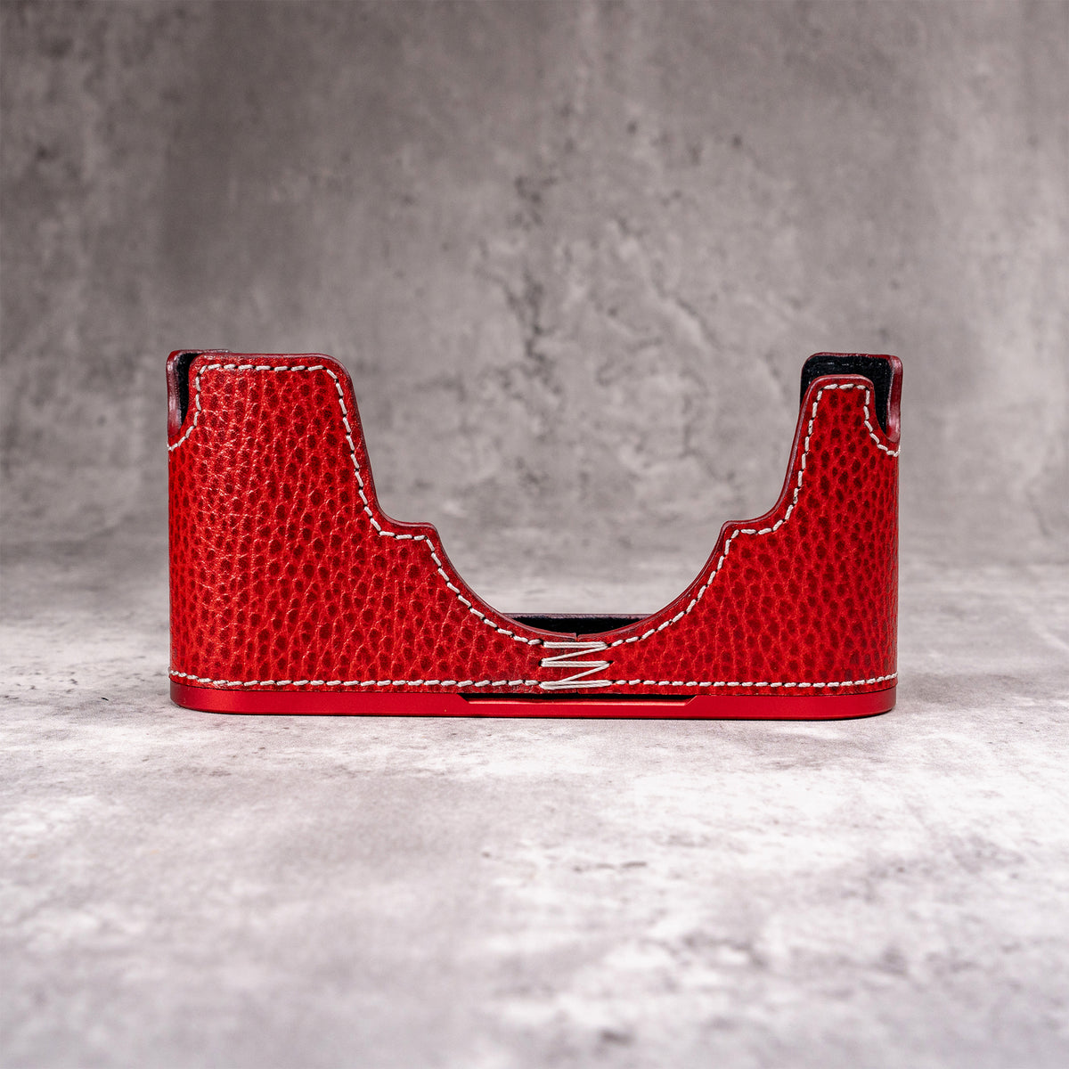 Ruby Gloss FlexCase on its own, front view of the red pebbled leather and cream stitching