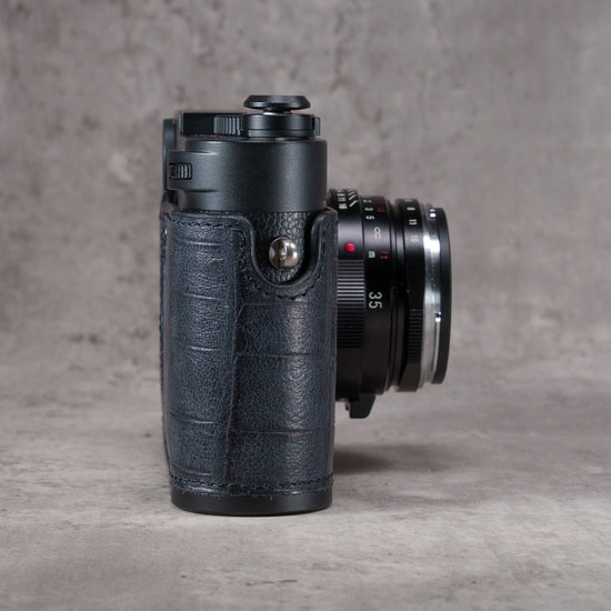 Black Swamp FlexCase, side view showing the gator pattern leather wrapping the grip and the strap lug
