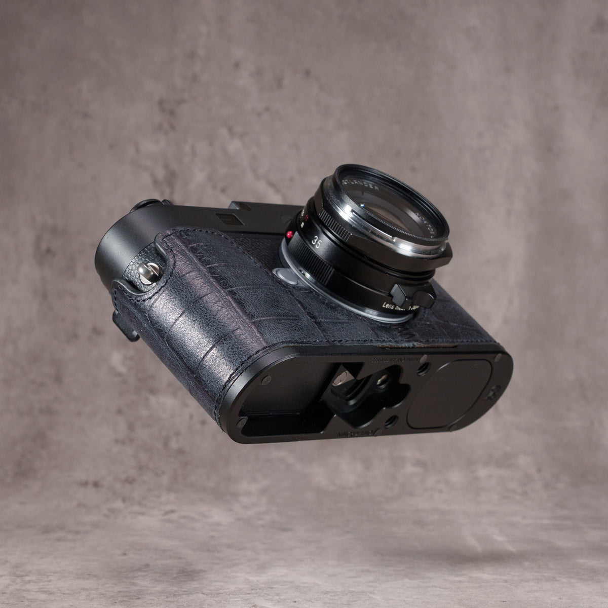 Black Swamp FlexCase underside from the left, showing the plate, the threads and the AirTag bay
