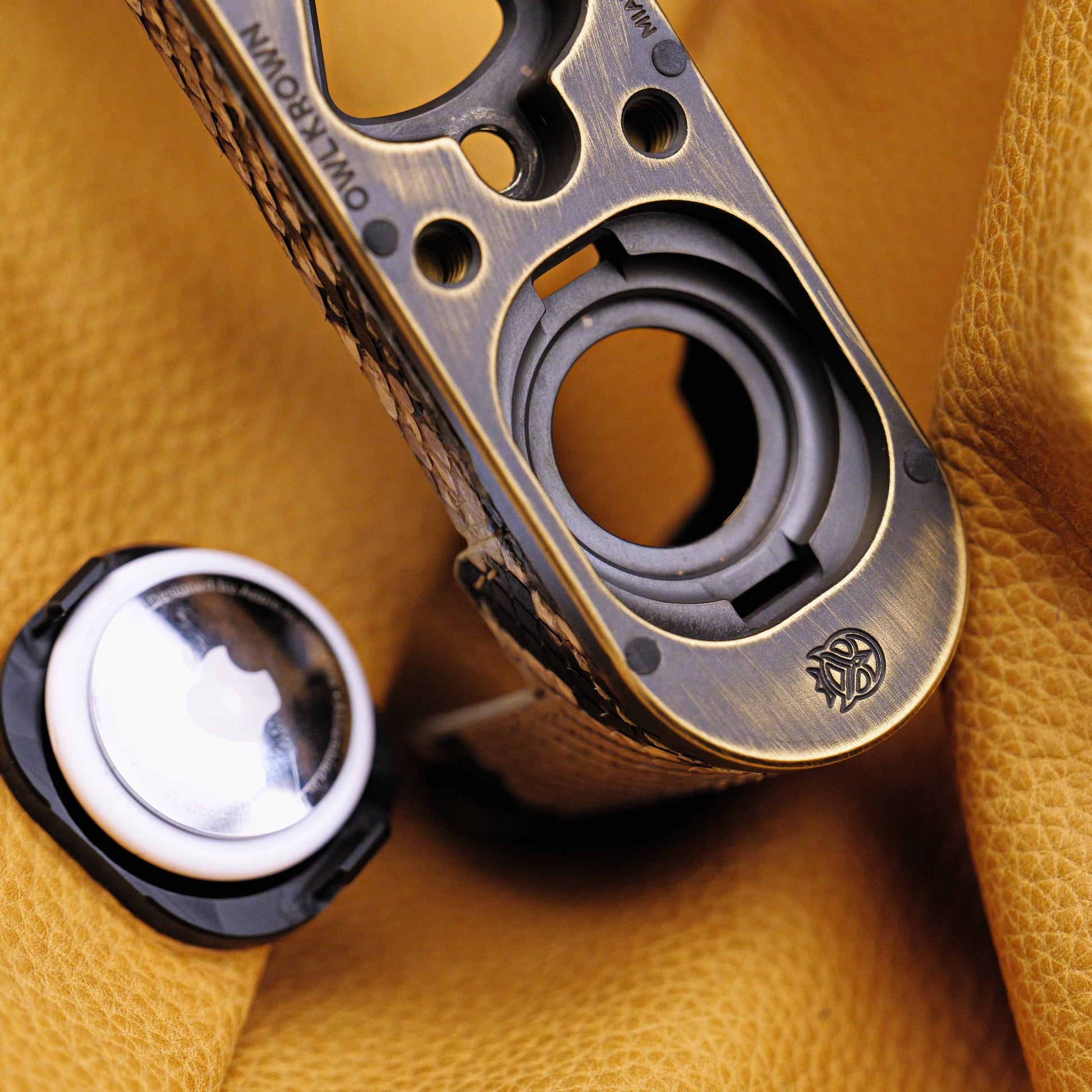 AirTag and the Owlkrown-engraved brass plate of the Python FlexCase