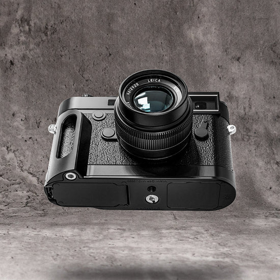 The Owlkrown FlexGrip fitted to a Leica M10, seen from the side on a concrete ground
