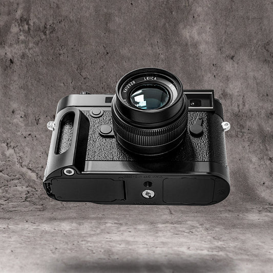The Owlkrown FlexGrip fitted to a Leica M10, seen from the side on a concrete ground
