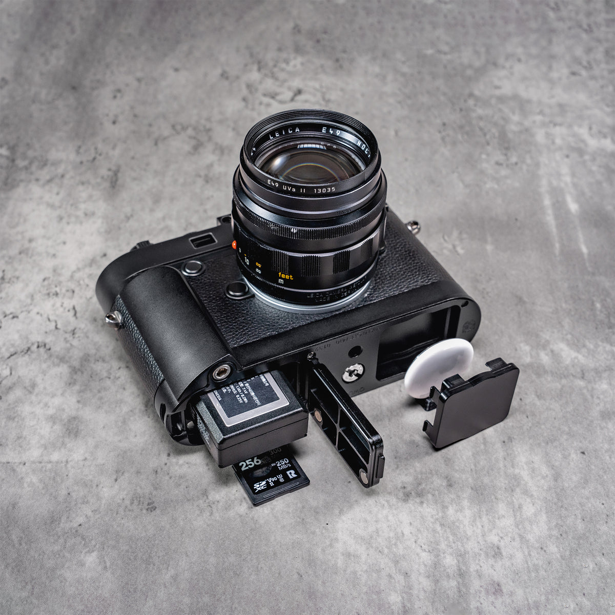 Leica M10 with the Black Chrome FlexGrip door open, the battery and memory card out beside it