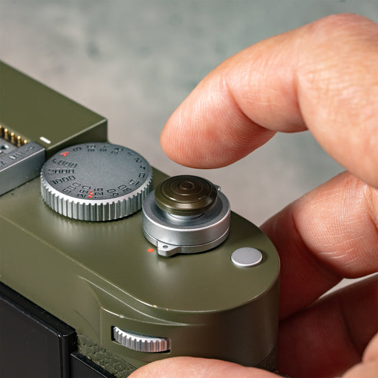 A finger resting on the Safari Shutter Topper, showing the added grip and shutter feel