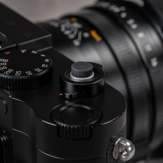 Black Cerakote Shutter Topper fitted to a black Leica M camera, angled view with lens and strap lug