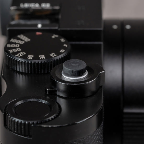 Black Cerakote Shutter Topper on a black Leica M top plate with shutter speed dial and lens in frame