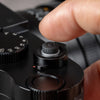 Photographer pressing the Black Cerakote Shutter Topper fitted to a black Leica M camera