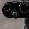 Overhead view of a Leica M top plate with the Black Cerakote Shutter Topper beside the shutter speed dial