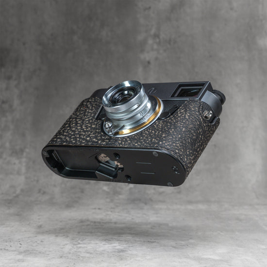 A Leica M11 in the Buffalo SlimCase seen from below with the battery compartment open