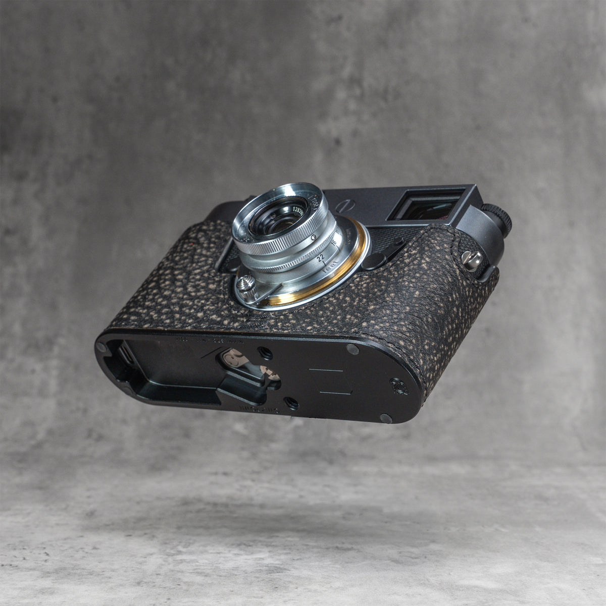 A Leica M11 in the Buffalo SlimCase seen from below with the battery compartment open