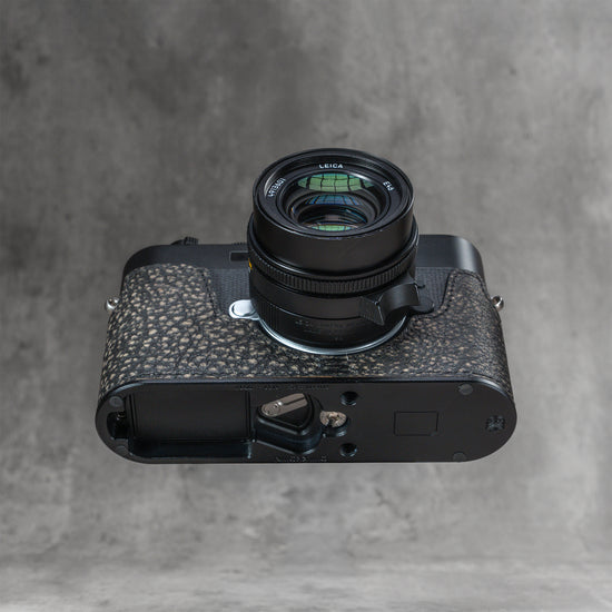 A Leica in the Buffalo SlimCase seen from underneath with a black lens fitted