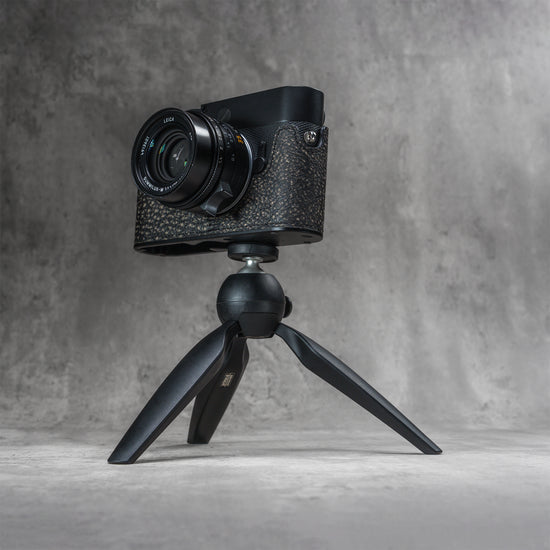 A Leica in the Buffalo SlimCase mounted on a small tripod through the thread in the base