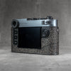 The back of a Leica M11 in the Buffalo SlimCase at an angle, screen and controls left clear