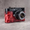 A Leica M11 in the Hot Lava SlimCase, three quarter front view with the lens attached