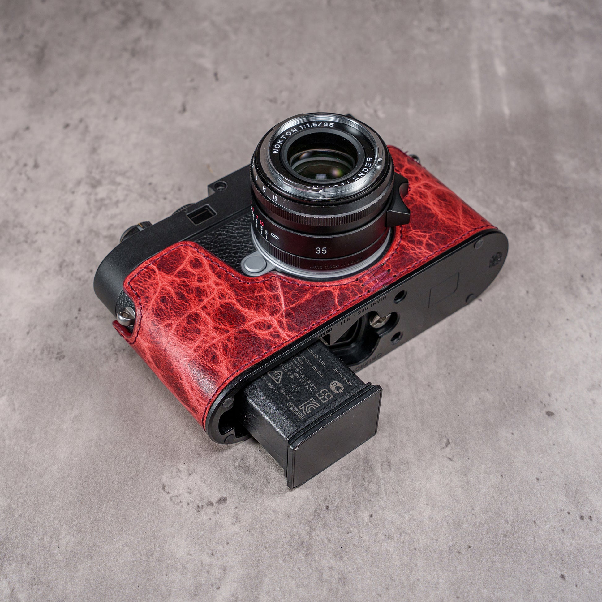 The base plate of the Hot Lava SlimCase with the battery door open on a Leica M11