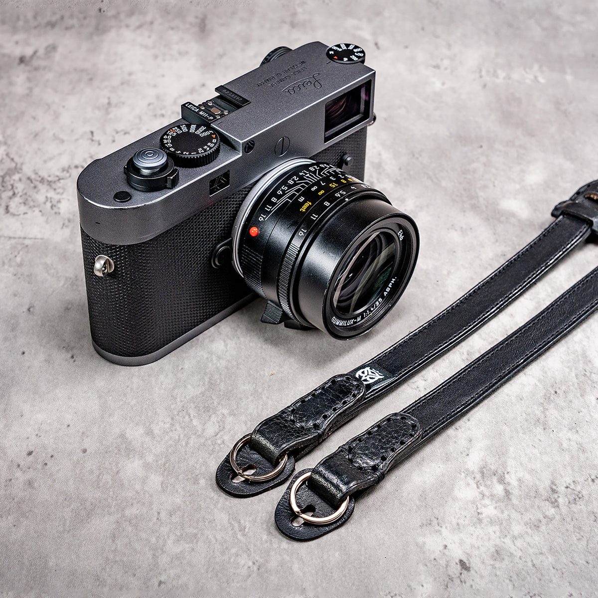 Stealth leather strap ends with split rings beside a Leica M