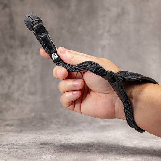 Hand in the Stealth padded WristFlex holding the strap end and split ring