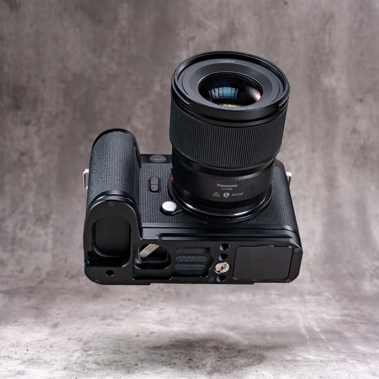 Leica SL3 and lens seen from below, showing the Owlkrown FlexPlate base and its 1/4-20 mounting points
