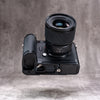 Leica SL3 and lens seen from below, showing the Owlkrown FlexPlate base and its 1/4-20 mounting points