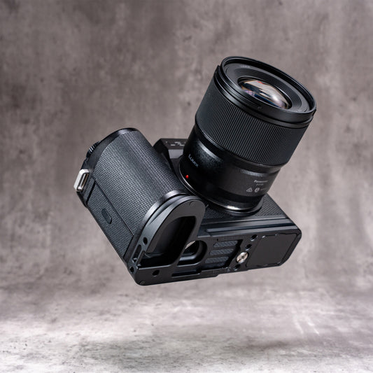 Leica SL3 with lens, tilted to show the underside of the Owlkrown FlexPlate and the pinky ledge