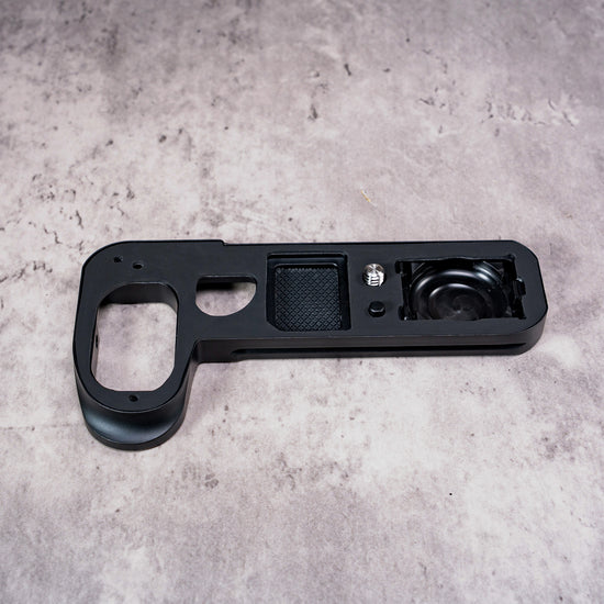Owlkrown FlexPlate for Leica SL3 laid flat, showing the anti-skid pad, mounting screw and AirTag bay