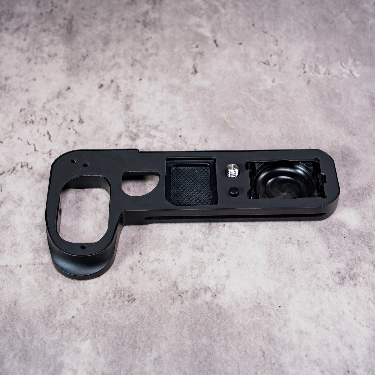 Owlkrown FlexPlate for Leica SL3 laid flat, showing the anti-skid pad, mounting screw and AirTag bay