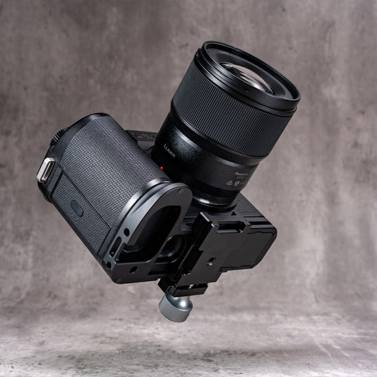 Leica SL3 and lens on the Owlkrown FlexPlate, tilted to show the base mounted to a tripod head