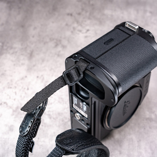 Owlkrown FlexPlate for Leica SL3 seen from above, with a strap looped through the side lug