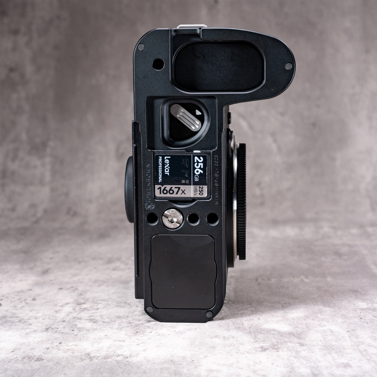 Underside of the Owlkrown FlexPlate for Leica SL3, showing the external card bay with a spare SD card loaded