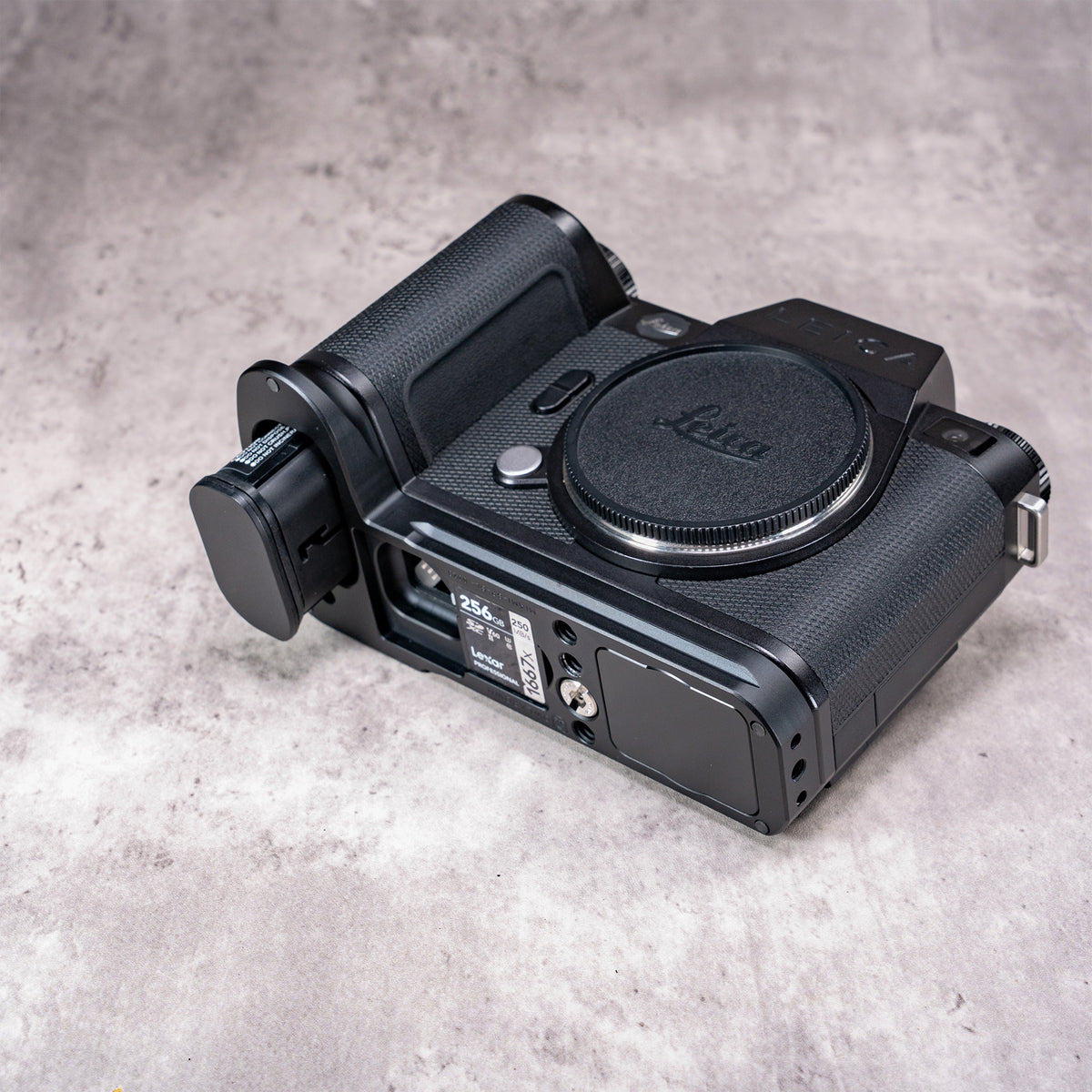 Leica SL3 with the Owlkrown FlexPlate fitted, angled view from above showing the spare card in the plate