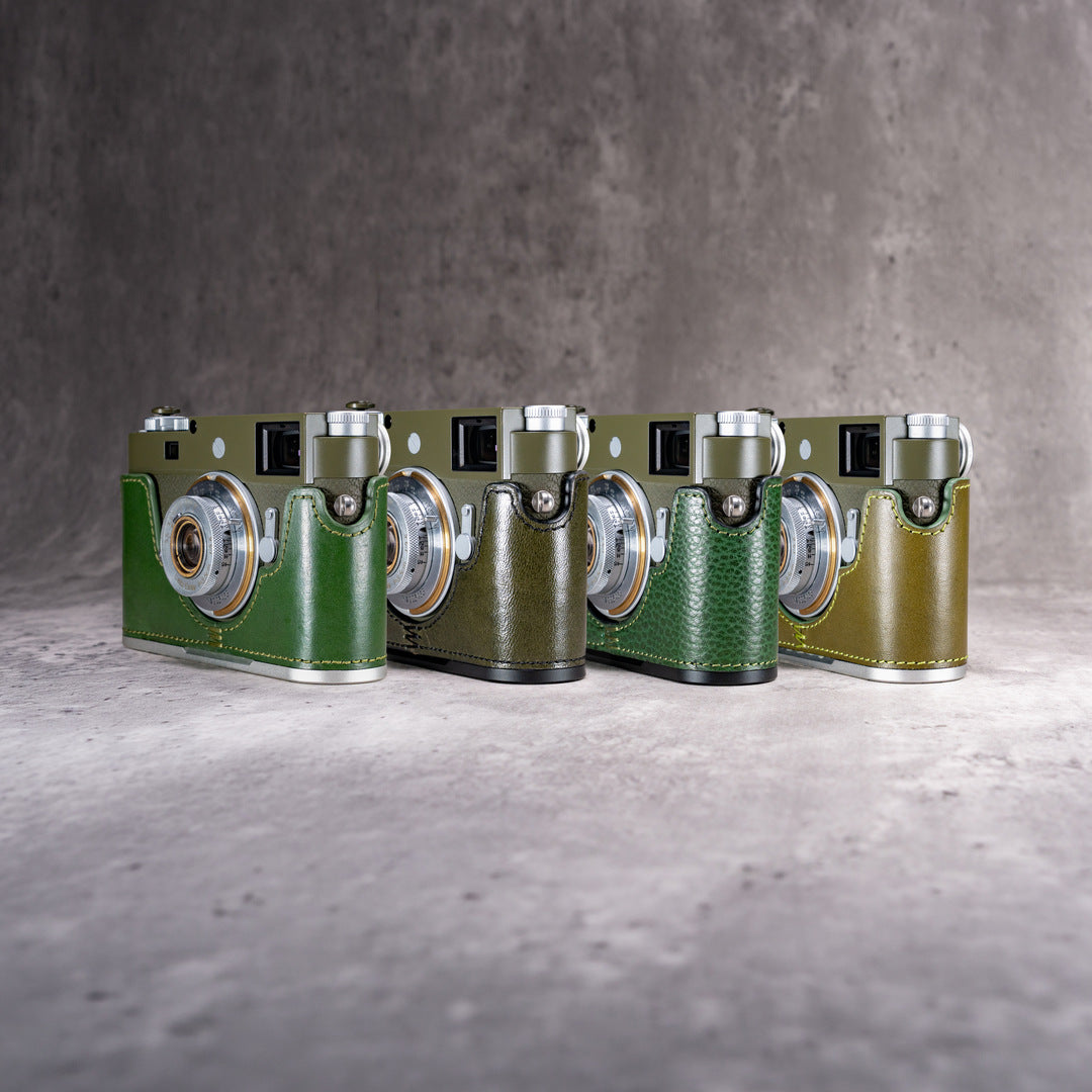 Four FlexCases in green leather on Leica M bodies, standing in a row on concrete